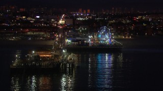 HD stock footage aerial video fly toward the Ferris wheel and rides at night, Santa Monica Pier, California Aerial Stock Footage | CAP_018_115