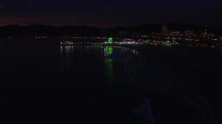 HD stock footage aerial video a slow approach to the Ferris wheel and rides at nighttime, Santa Monica Pier, California Aerial Stock Footage | CAP_018_117