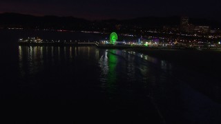 HD stock footage aerial video approach the Ferris wheel and rides at nighttime, Santa Monica Pier, California Aerial Stock Footage | CAP_018_118