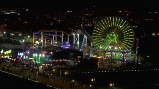 HD stock footage aerial video flying around the Ferris wheel and rides at nighttime, Santa Monica Pier, California Aerial Stock Footage | CAP_018_123