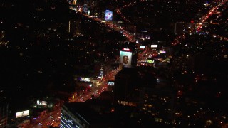 HD stock footage aerial video approach billboard by the Sunset Strip at night in West Hollywood, California Aerial Stock Footage | CAP_018_126