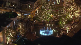 HD stock footage aerial video of an orbit around a fountain at The Grove shopping mall at night in Los Angeles, California Aerial Stock Footage | CAP_018_150