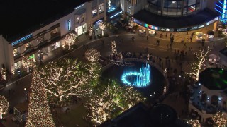 HD stock footage aerial video of orbiting Christmas decorations and fountain at The Grove shopping mall at night in Los Angeles, California Aerial Stock Footage | CAP_018_163