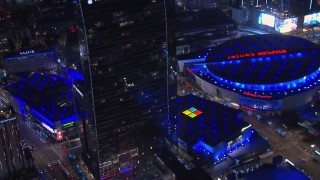 CAP_018_190 - HD stock footage aerial video of flying by hotel and theater to reveal ice skating at night, Downtown Los Angeles, California