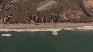 HD stock footage aerial video of passing by an empty strip of beach as waves roll toward the coast, Oceanside, California Aerial Stock Footage | CAP_021_039