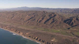 HD stock footage aerial video of flying by I-5 between mountains and coastal cliffs, San Clemente, California Aerial Stock Footage | CAP_021_042