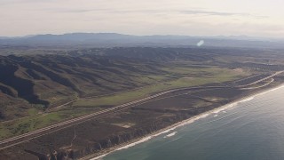 HD stock footage aerial video of a reverse view of I-5 between mountains and coastal cliffs, San Clemente, California Aerial Stock Footage | CAP_021_043