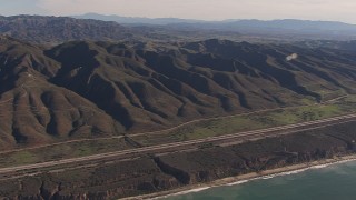 HD stock footage aerial video of panning across I-5 between mountains and coastal cliffs, San Clemente, California Aerial Stock Footage | CAP_021_044