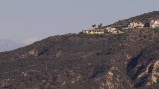 HD stock footage aerial video flyby hillside mansions to focus on distant snowy mountains in Dana Point, California Aerial Stock Footage | CAP_021_065