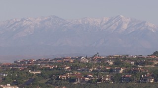 HD stock footage aerial video of distant snowy mountains seen from hilltop mansions, Laguna Beach, California Aerial Stock Footage | CAP_021_073