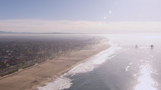 HD stock footage aerial video of flying away from a pier and the beach in Huntington Beach, California Aerial Stock Footage | CAP_021_084