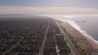 HD stock footage aerial video of a reverse view of a pier and the beach in Huntington Beach, California Aerial Stock Footage | CAP_021_085