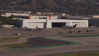 CAP_021_133 - HD stock footage aerial video of civilian jets and helicopters by a Burbank Airport hangar, California