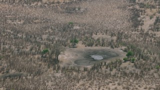 CAP_026_039 - HD stock footage aerial video of orbiting a nearly dry pond in the savanna, Zimbabwe