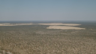 HD stock footage aerial video of passing by clearings in the trees and brush in the savanna, Zimbabwe Aerial Stock Footage | CAP_026_043