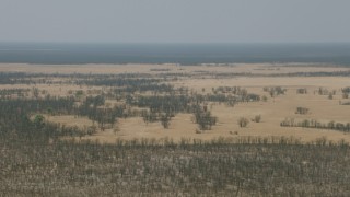 HD stock footage aerial video of passing by grassy clearings in the trees and brush in the savanna, Zimbabwe Aerial Stock Footage | CAP_026_044