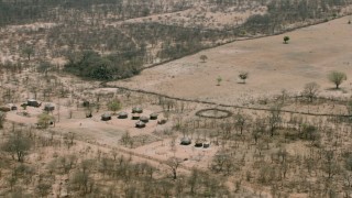 HD stock footage aerial video of circling huts by fields in a small village, Zimbabwe Aerial Stock Footage | CAP_026_060