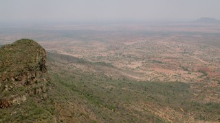 CAP_026_098 - HD stock footage aerial video of approaching a village from green mountains in Zimbabwe