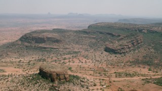 CAP_026_099 - HD stock footage aerial video of flying by a village beside green mountains in Zimbabwe