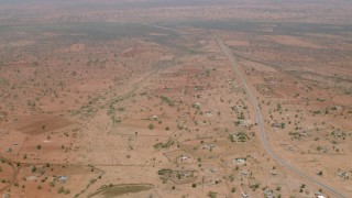 HD stock footage aerial video of flying over a village and tilt to homes by the road in Zimbabwe Aerial Stock Footage | CAP_026_103