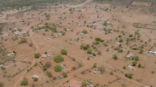 HD stock footage aerial video of flying over an African village, tilt to the houses below, Zimbabwe Aerial Stock Footage | CAP_026_115