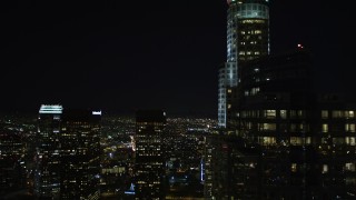 DCA01_017 - 5K aerial stock footage following 5th Street, tilt up revealing skyscrapers and city lights in Downtown Los Angeles at night, California