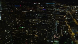 DCA01_053E - 5K aerial stock footage flying by and orbiting skyscrapers in Downtown Los Angeles at night, California