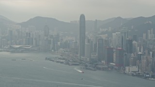 4K aerial stock footage tilt from a ferry and pan across Hong Kong Island and Victoria Harbor to reveal Kowloon, China Aerial Stock Footage | DCA02_015