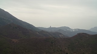 DCA02_038 - 4K aerial stock footage flyby mountains to reveal Ngong Ping Cable Car gondolas and Tian Tan Buddha on Lantau Island, Hong Kong, China