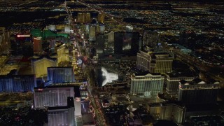 4K aerial stock footage of hotels along Las Vegas Strip, approaching Paris and Bellagio Fountain water show, Nevada Night Aerial Stock Footage | DCA03_129