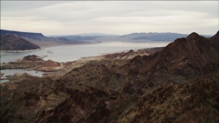 4K aerial stock footage of flying over rocky ridge in Hiller Mountains, revealing Lake Mead, Nevada Aerial Stock Footage | DCA04_082