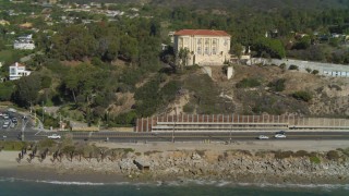 DCA05_100 - 4K aerial stock footage of tilting from the coastline to reveal mansion on a hill Pacific Palisades, California