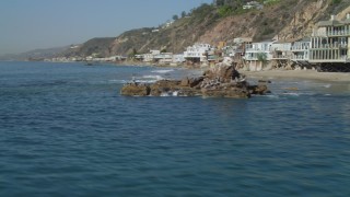 4K aerial stock footage of flying by birds on a rock formation, coastal homes, Malibu, California Aerial Stock Footage | DCA05_106