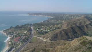 4K aerial stock footage of flying over a hill, revealing coastal community of Malibu, California Aerial Stock Footage | DCA05_125