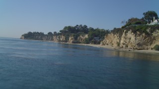 DCA05_129 - 4K aerial stock footage of flying low over the ocean near coastal cliffs and beach, Malibu, California