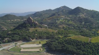 4K aerial stock footage pan across vineyards, revealing hilltop rock formation, Malibu, California Aerial Stock Footage | DCA05_134