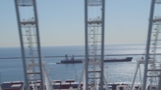 4K aerial stock footage of flying away from oil tanker to reveal cargo cranes at Port of Long Beach, California Aerial Stock Footage | DCA06_027