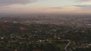 4K aerial stock footage of flying over Hollywood Hills, revealing Downtown skyline, Los Angeles, California, sunset Aerial Stock Footage | DCA07_001