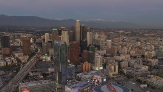 4K aerial stock footage of flying by Downtown skyscrapers, over Highway 110, mountains in the distance, Los Angeles, California, twilight Aerial Stock Footage | DCA07_012