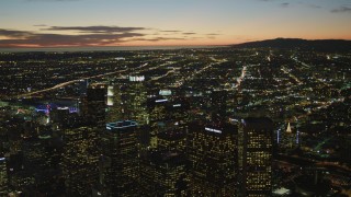 4K aerial stock footage of flying by Downtown skyscrapers, coast and clouds in the distance, Los Angeles, California, twilight Aerial Stock Footage | DCA07_053