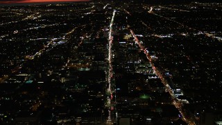 DCA07_066 - 4K aerial stock footage of following Wilshire Blvd through Koreatown and tilt to a wider view of Los Angeles, California, night