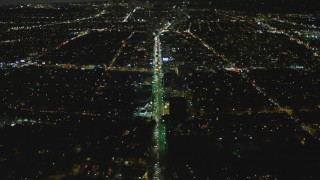 4K aerial stock footage of following Wilshire Blvd toward Century City, tilt down, Mid-Wilshire, Los Angeles, California, night Aerial Stock Footage | DCA07_074