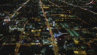 4K aerial stock footage of following Sunset Boulevard, tilt down on Cinerama Dome, Hollywood, California, night Aerial Stock Footage | DCA07_083