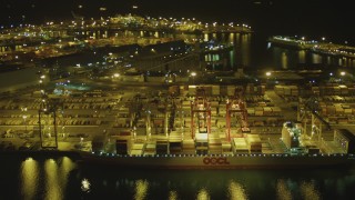 4K aerial stock footage of flying by cargo ship, cranes, containers, Port of Long Beach, California, night Aerial Stock Footage | DCA07_134