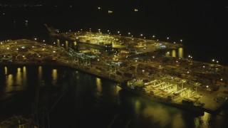 DCA07_139 - 4K aerial stock footage of approaching cargo containers, cranes at the Port of Long Beach, California, night