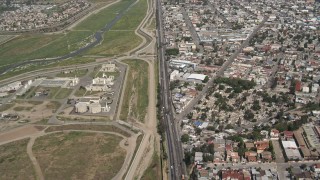 4K aerial stock footage of following a border highway and fence on the US/Mexico Border, Tijuana Aerial Stock Footage | DCA08_046