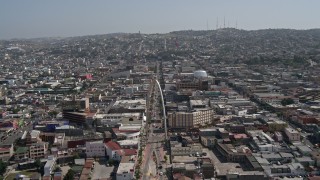 DCA08_060 - 4K aerial stock footage of following a street to approach Tijuana Arch, Tijuana, Mexico