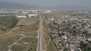 DCA08_065E - 4K aerial stock footage pass urban homes to approach warehouses and Tijuana International Airport, US/Mexico Border, Tijuana