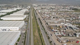 DCA08_069E - 4K aerial stock footage of flying over border fence past warehouses, US/Mexico Border, Tijuana