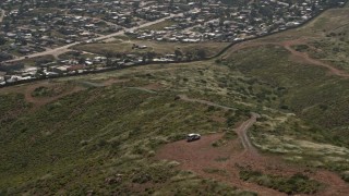 4K aerial stock footage orbit Border Patrol and tilt to reveal Tijuana homes, US/Mexico Border, Tijuana Aerial Stock Footage | DCA08_076